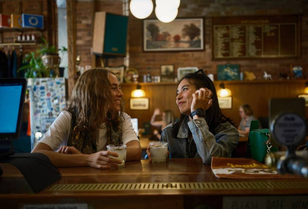 two women having a drink and gazing at each other at Love Shack Brewing