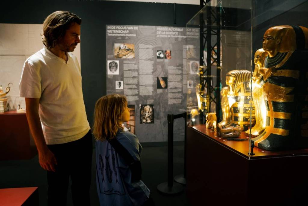 A father and son look at medium-size replicas of sarcophaguses at Treasures of Tutankhamun.