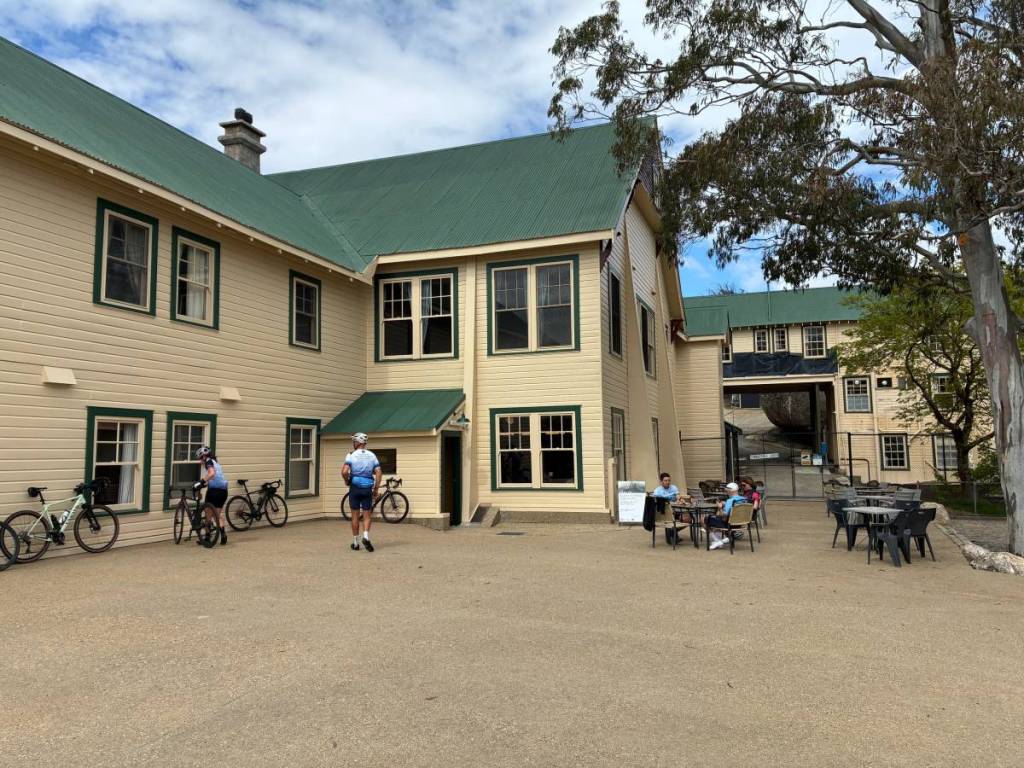 cyclists resting their bikes against the wall while people dine outside the Mount Buffalo Chalet Cafe