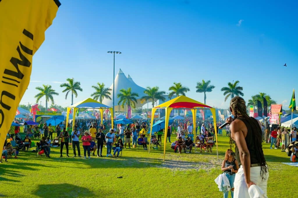 Grace Jamaican Jerk Festival grounds with tents, attendees and a performer