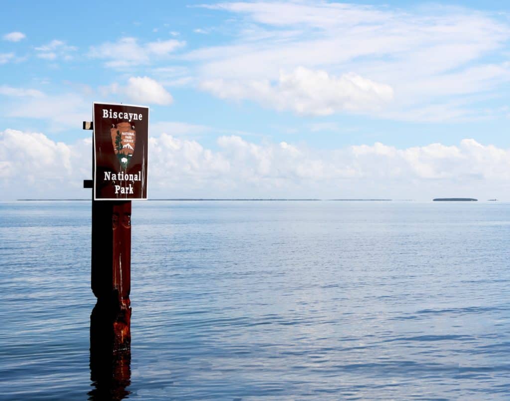 Un panneau indiquant le parc national de Biscayne, dans l'eau de mer de la baie.