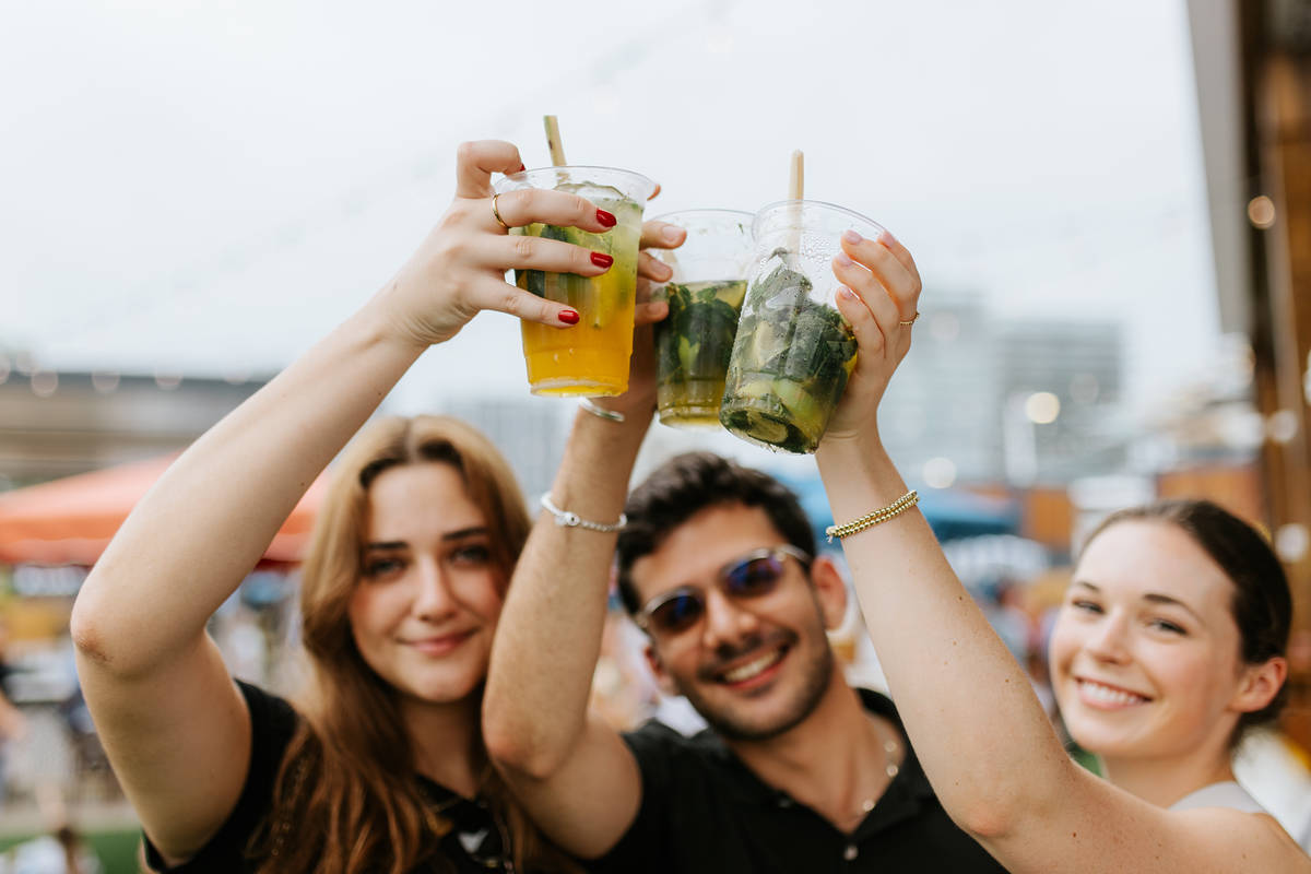 Three people holding up their drinks