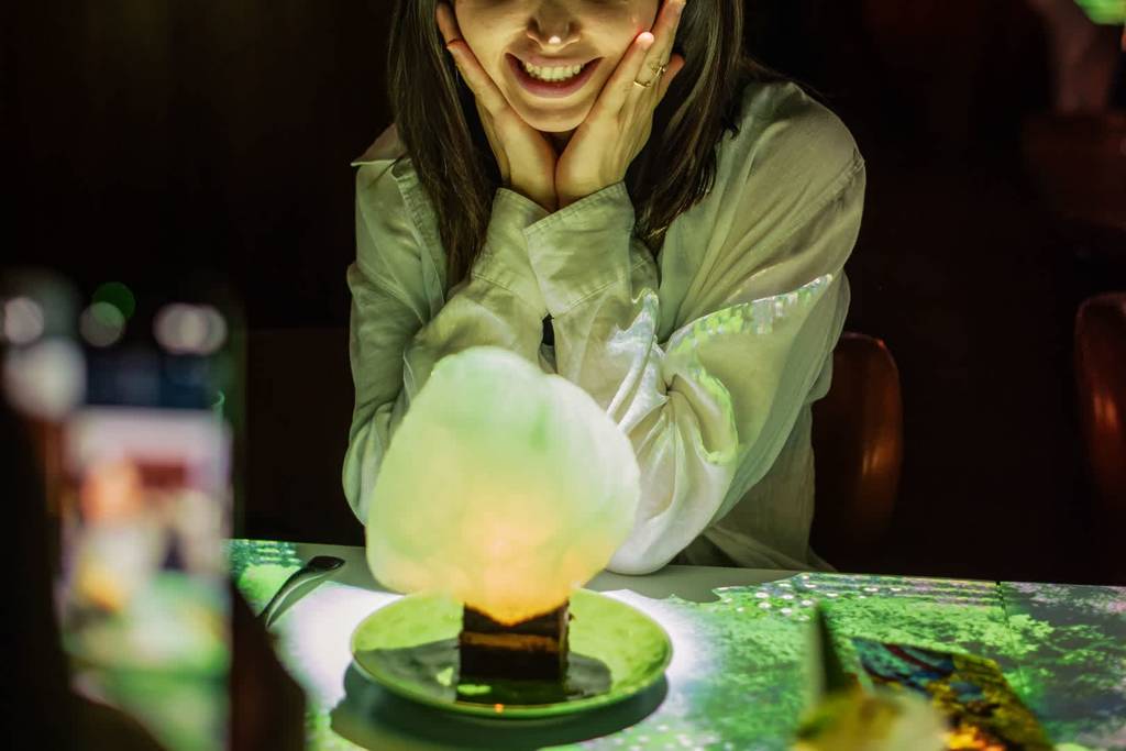 girls looks in awe at exciting desert on a lit up table at sensory feast