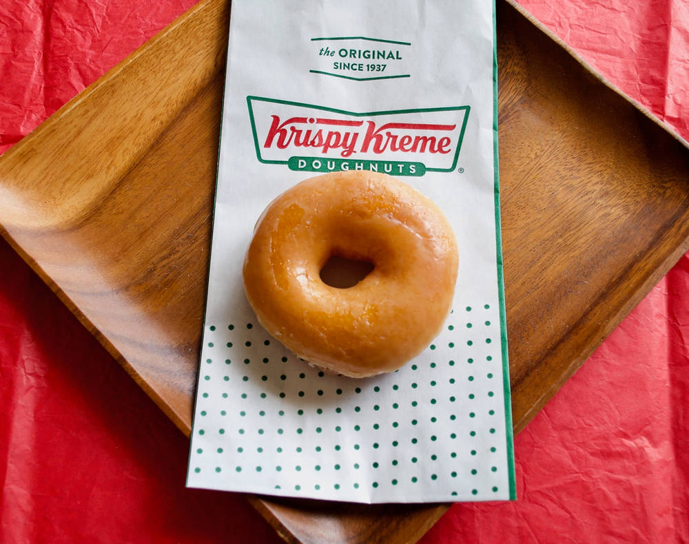 A Krispy Kreme Original Glazed doughnut with Krispy Kreme logo