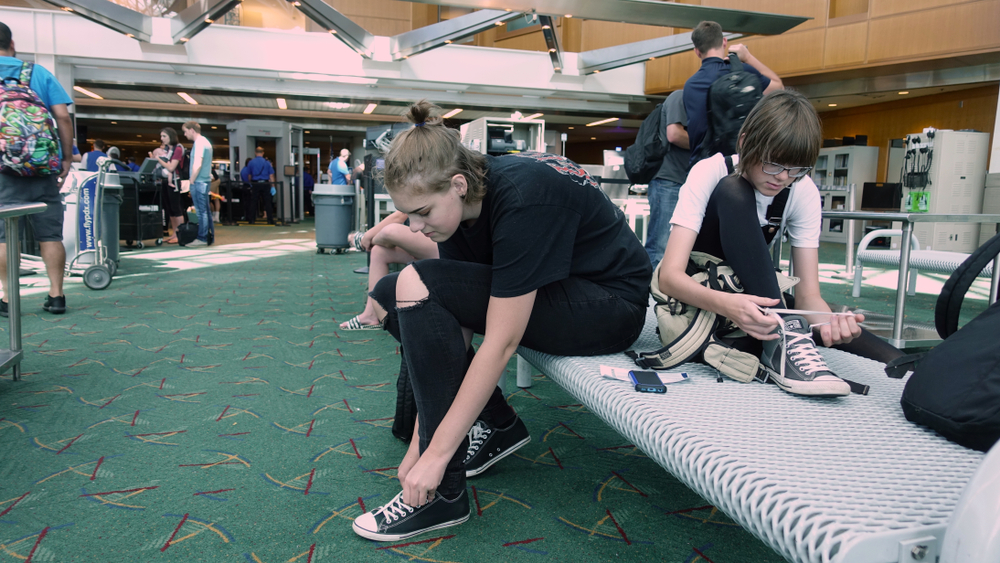 Travelers put their shoes back on after clearing airport security