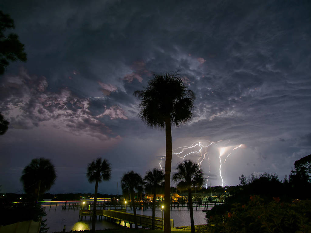 Relâmpagos assustadores sobre a marina da Flórida iluminam as nuvens ameaçadoras e o rio Anclote, Tarpon Springs, Flórida
