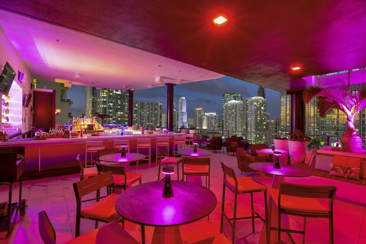 An inside shot of Rosa Sky at night with the Miami skyline visible through the windows