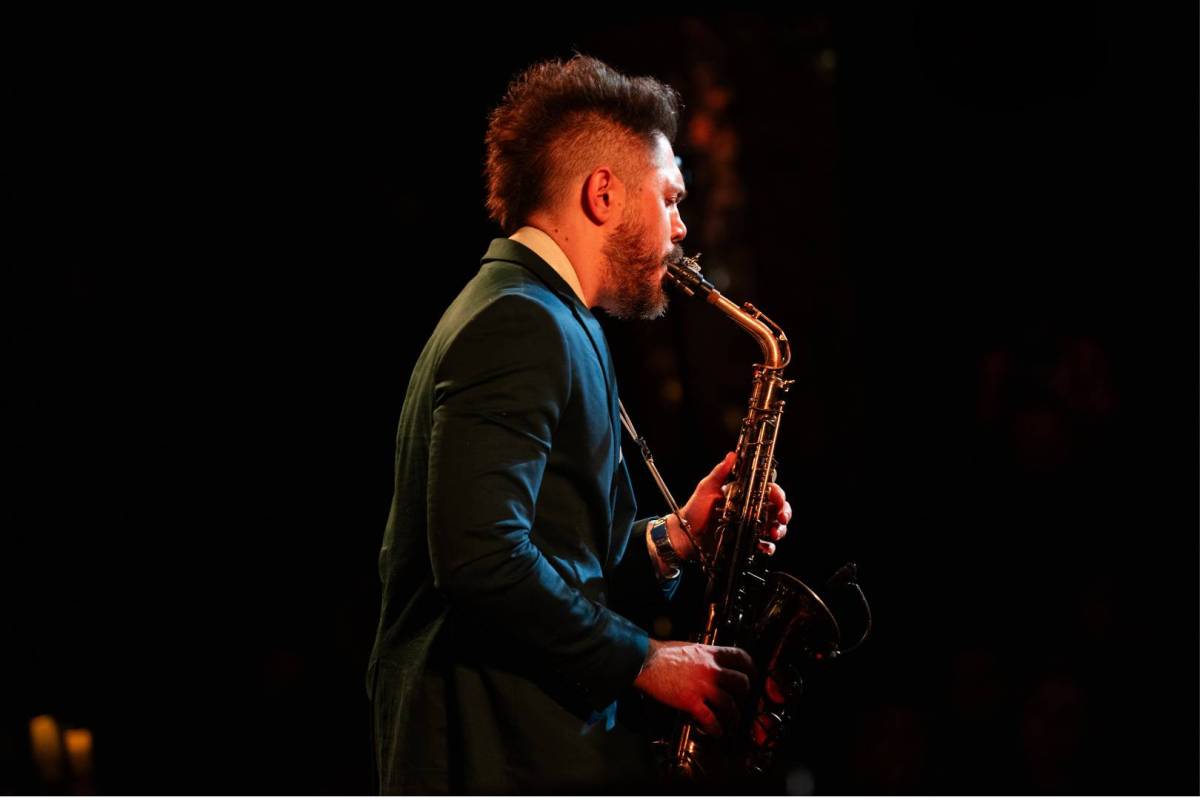 man plays saxophone while performing at the jazz room