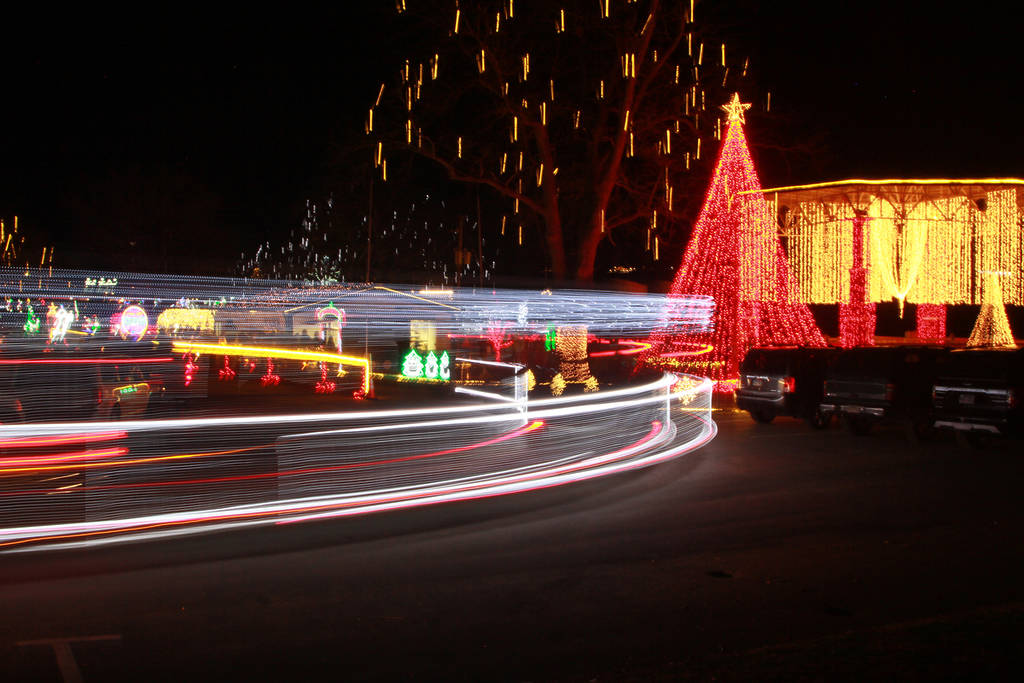 Slow Exposure of a Tram Decorated like a Train Circling Through a Drive Thru Christmas Light Display