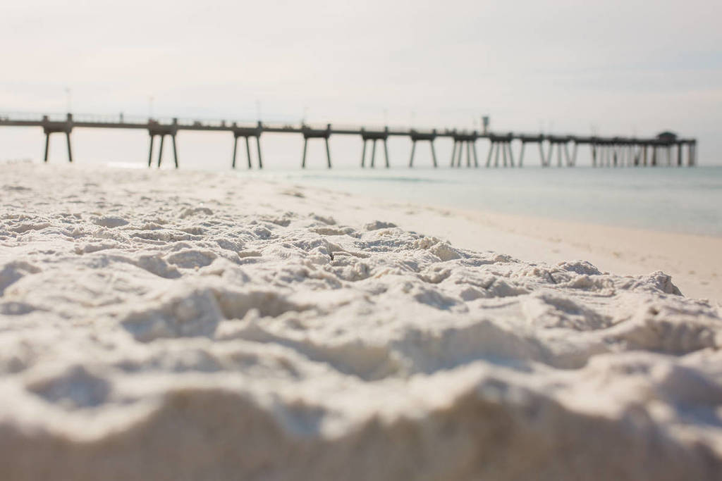 Muelle de Fort Walton Beach con arena blanca en primer plano.
