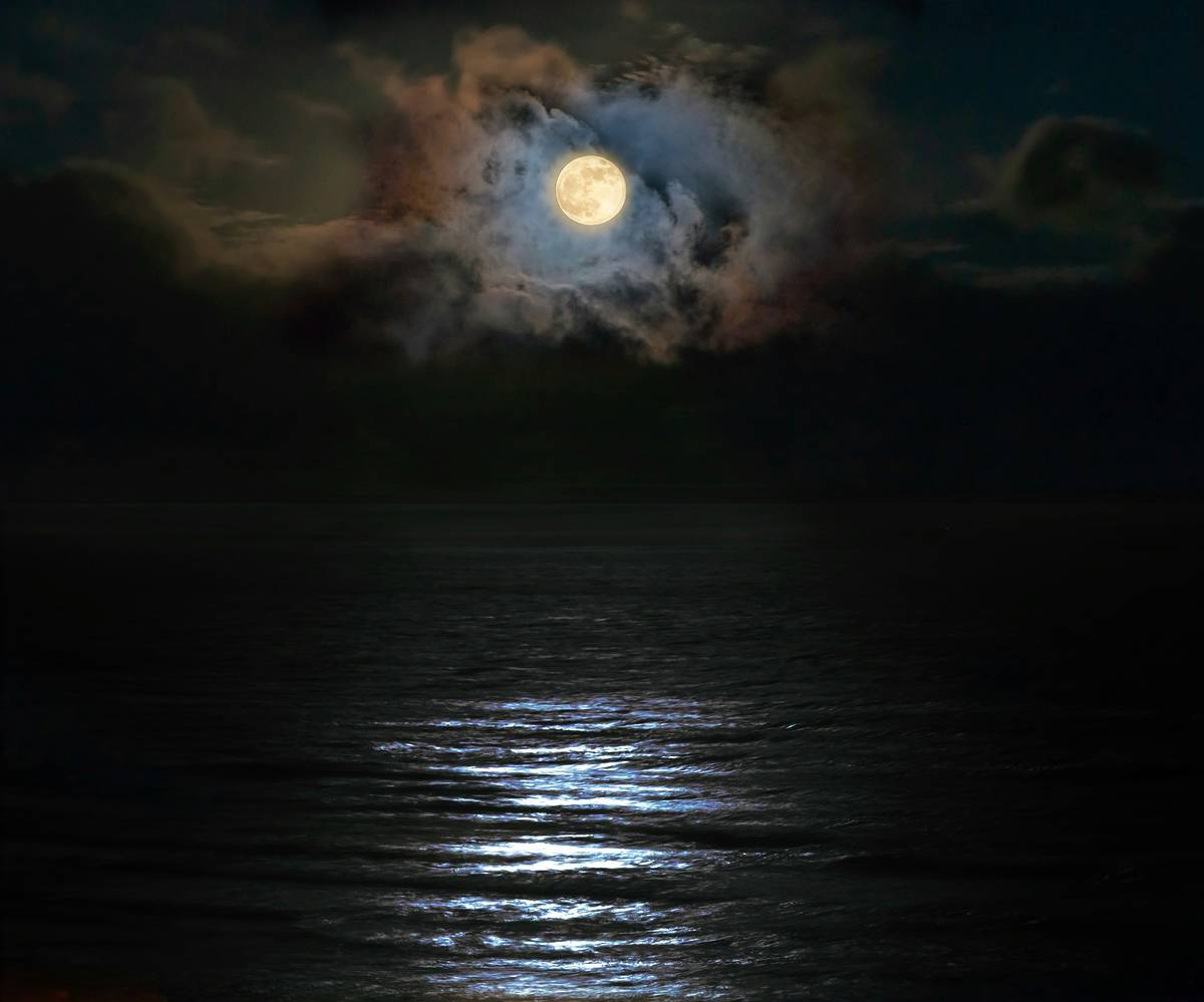 Full moon at night over the ocean