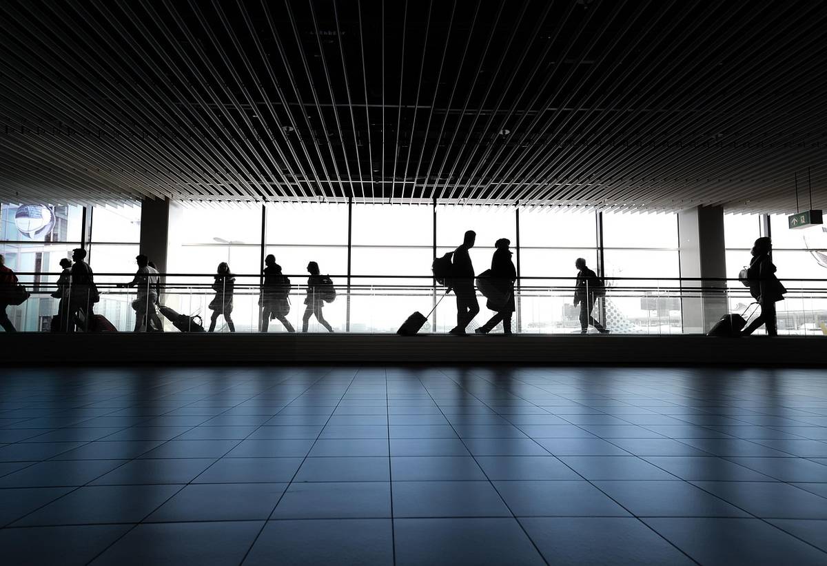 People's silhouettes at an airport