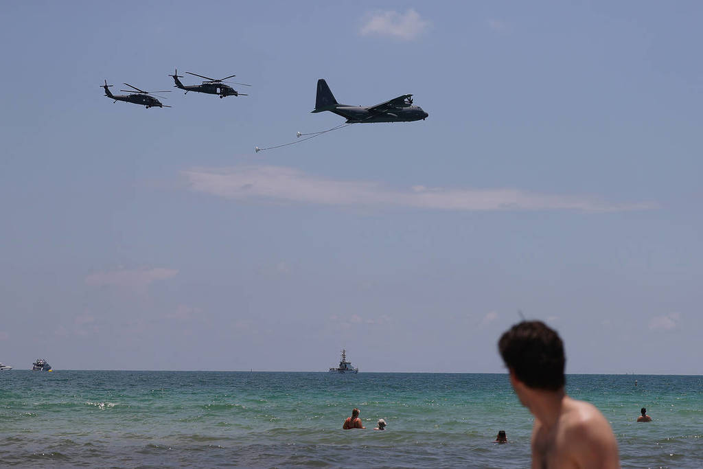 MIAMI BEACH, FLÓRIDA — 28 DE MAIO: Banhistas observam enquanto uma aeronave de reabastecimento HC-130-P/N “King” e dois helicópteros HH-60G Pave Hawk praticam manobras antes do Hyundai Air and Sea Show em 28 de maio de 2021 em Miami Beach, Flórida. O Air and Sea Show faz parte do National Salute to America’s Heroes, ao longo da orla de South Beach, apresentado pela Hyundai durante o fim de semana prolongado do Memorial Day. O evento homenageia e presta tributo aos militares e socorristas que fizeram o sacrifício máximo.