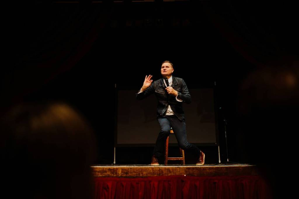 Ein Stand-up-Comedian tritt auf einer erhöhten Bühne auf