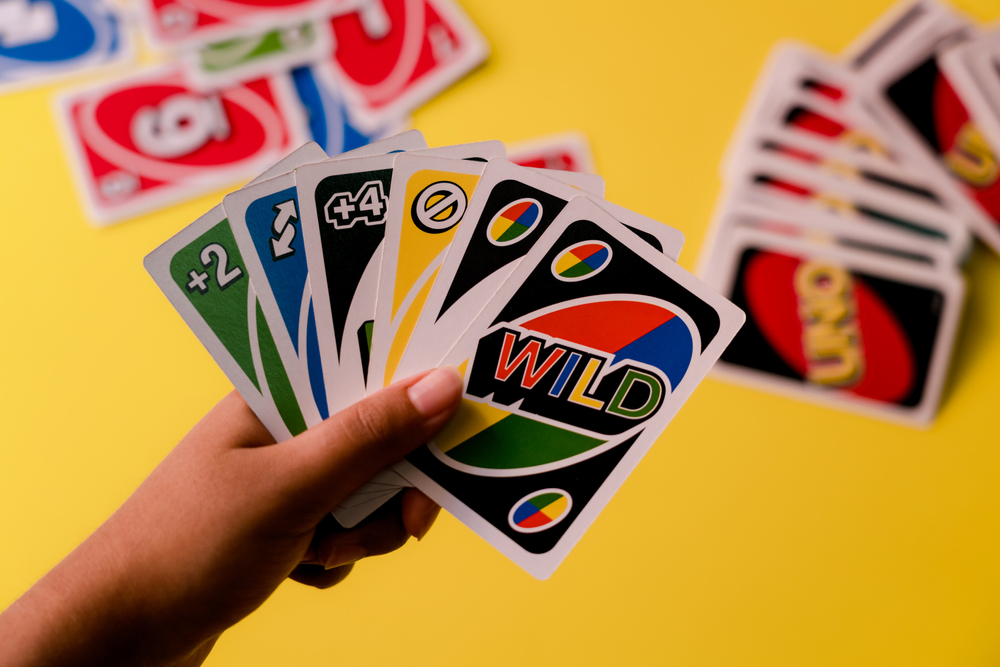 Cartas de UNO contra um baralho de cartas em um fundo amarelo