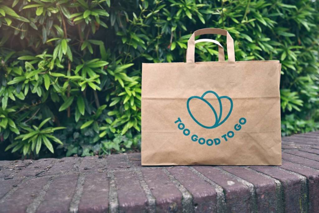 Ulm, Allemagne - 7 mai 2025 : Sac en papier contenant des aliments dont la date de péremption est proche, sauvés du gaspillage grâce à l’appli Too Good To Go. Faire ses courses zéro déchet via une appli qui lutte contre le gaspillage alimentaire.