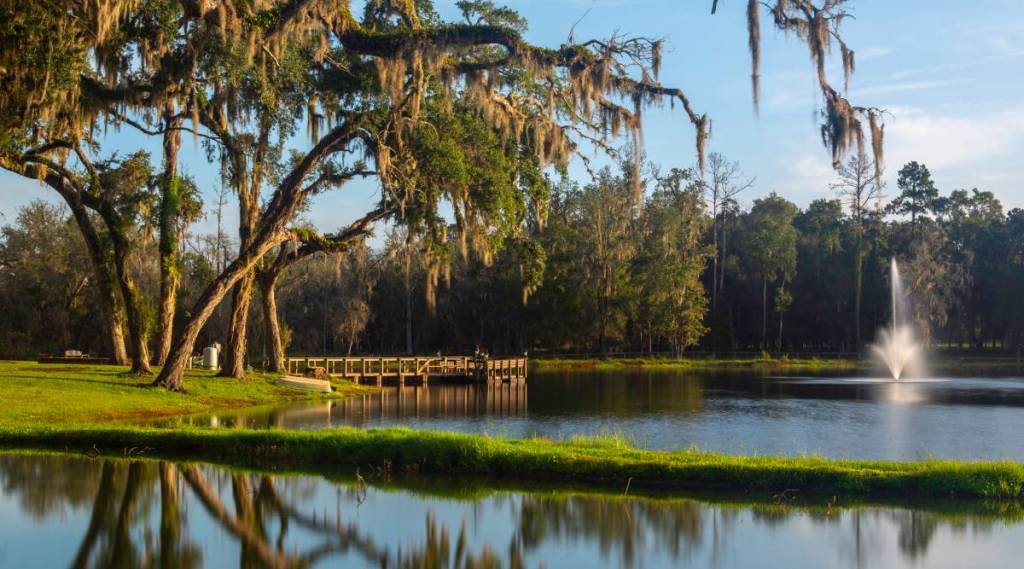 BROOKSVILLE, FL/USA - SEPTEMBER 15, 2019 The dock and fountain at Belle Parc, framed by overhanging trees on the west bank of the lake at Belle Parc RV Resort, a 270-site on US 41 in central Florida.