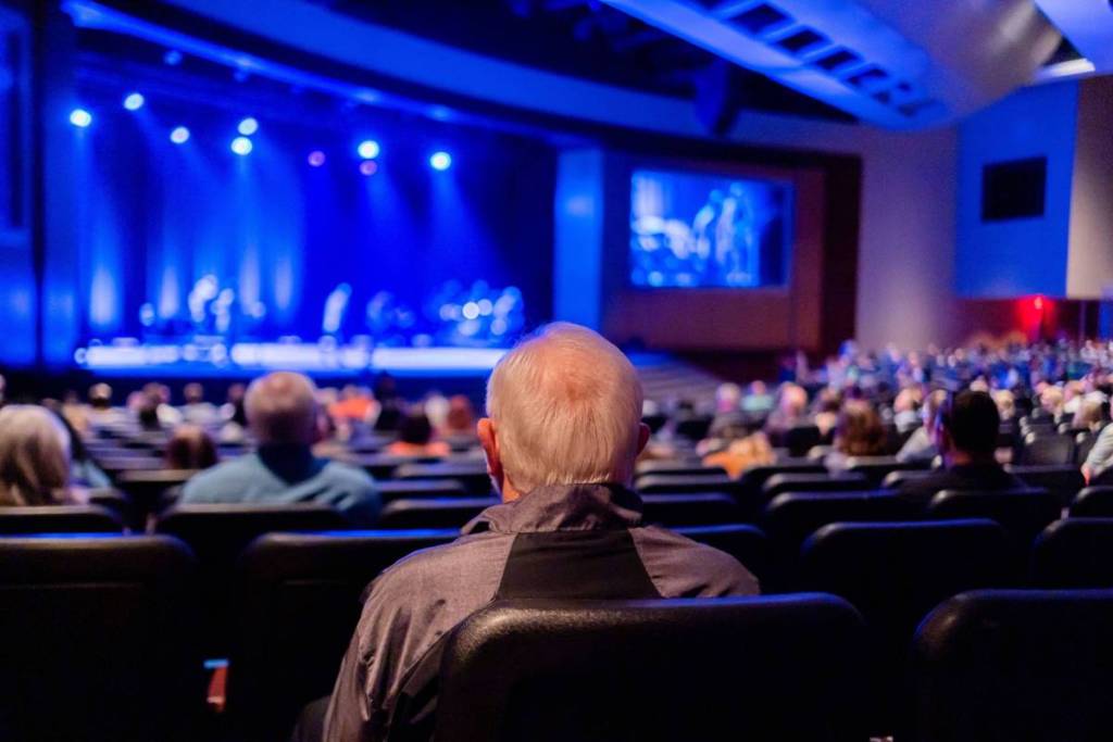 Audience seated in a theater watching a captivating live performance on stage