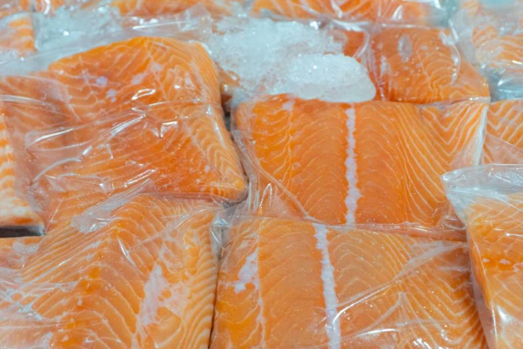 Fresh Salmon fish packing in transparent plastic bag on ice at fish market,Frozen food,selective focus