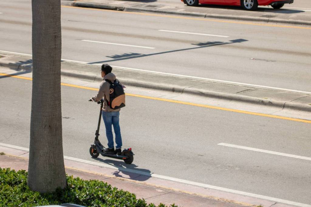 MIAMI, USA - April 4, 2025: A boy on a scooter on street.