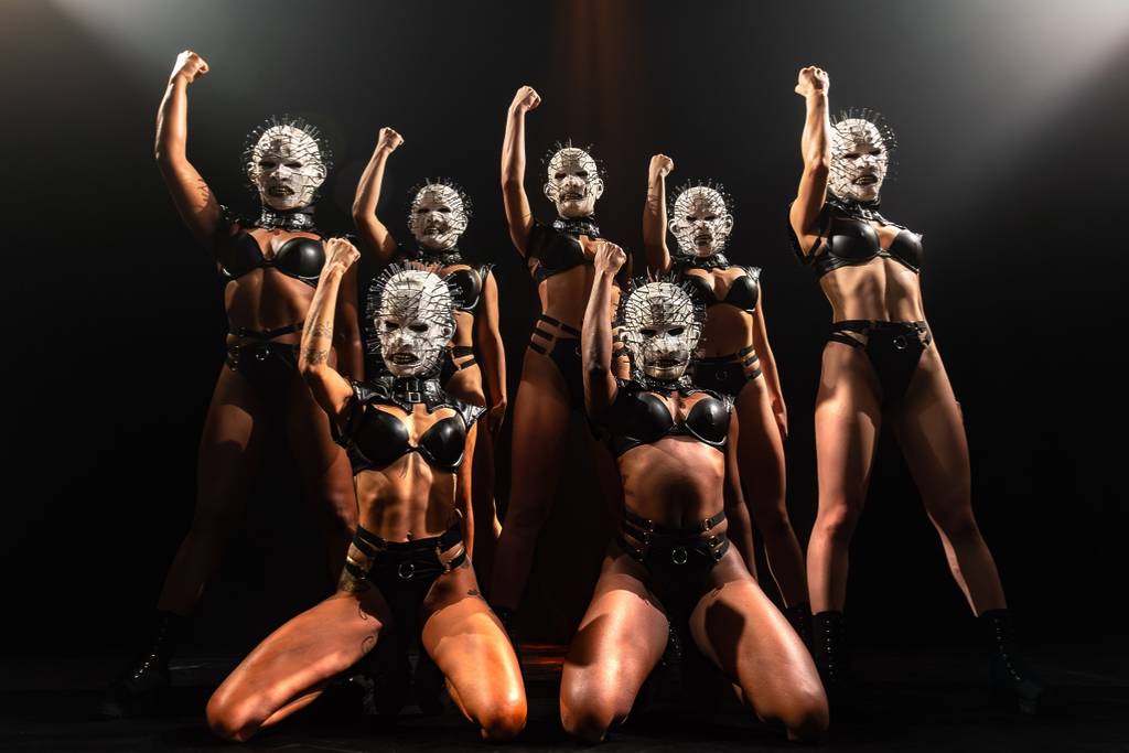 Burlesque performers wear horror-themed outfits onstage