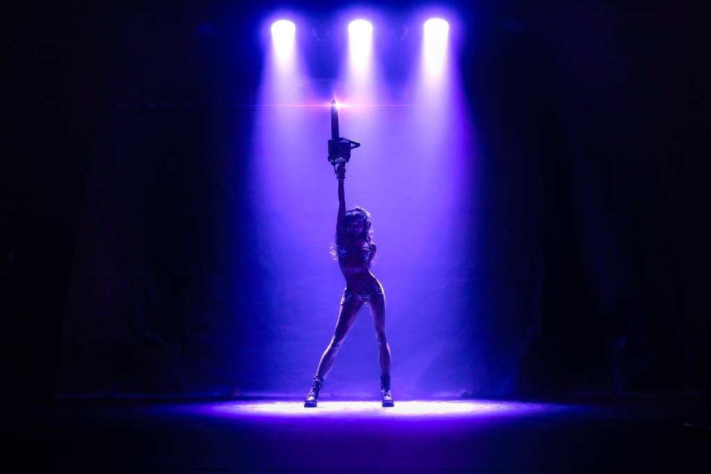 Burlesque performers wear horror-themed outfits onstage