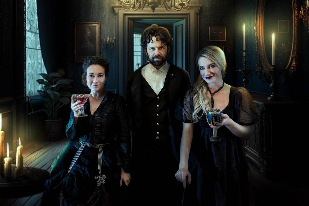 trio in Victorian-era clothing holding cocktails