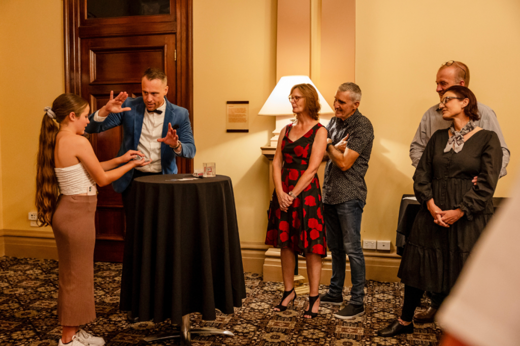 A group of people watching a magic trick in a hotel
