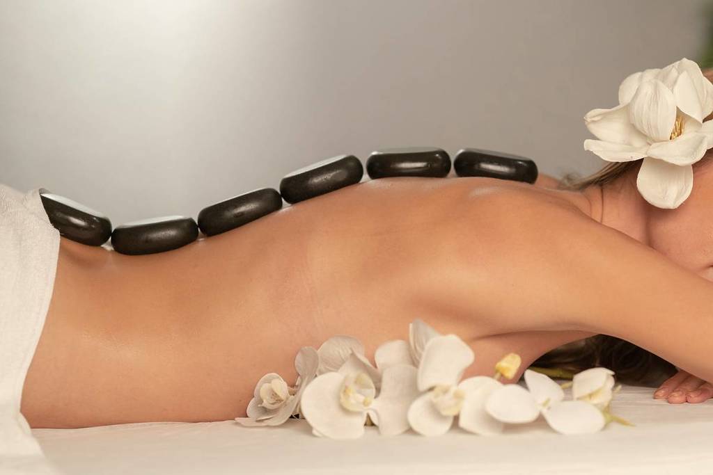 woman with hot stones on her back, spa for rainy days