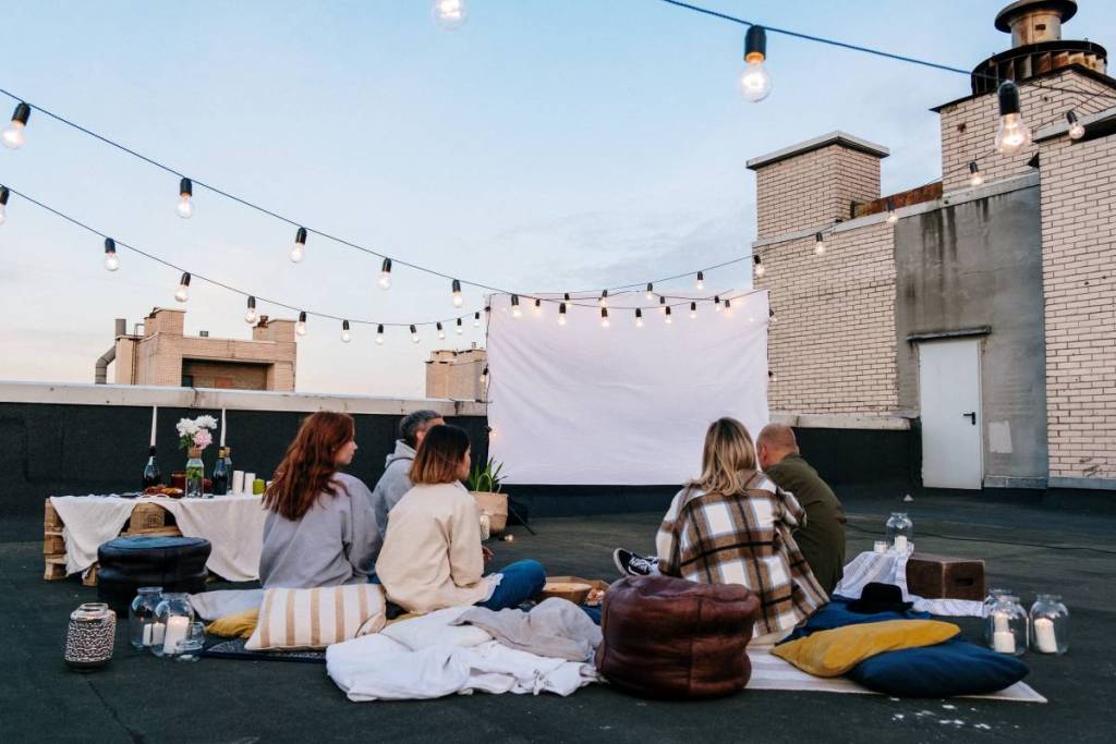 leute in einem open-air-kino auf einer dachterrasse