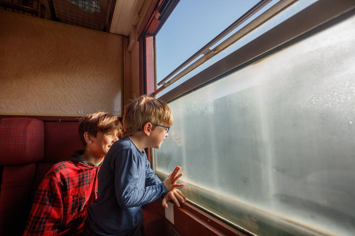 Kinder schauen aus dem Zug