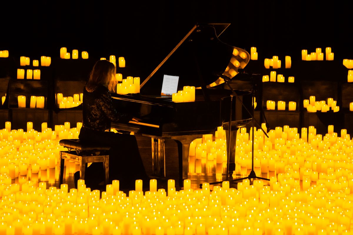 Pianist spielt bei einem Candlelight-Konzert auf einem Flügel, umringt von etlichen Kerzen