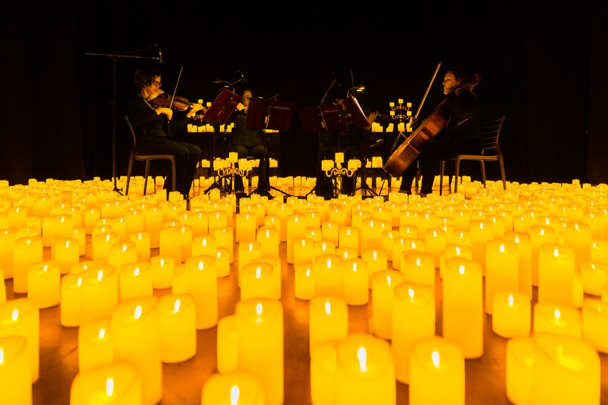 Streichquartett spielt bei einem Candlelight-Konzert auf der Bühne, umringt von etlichen Kerzen