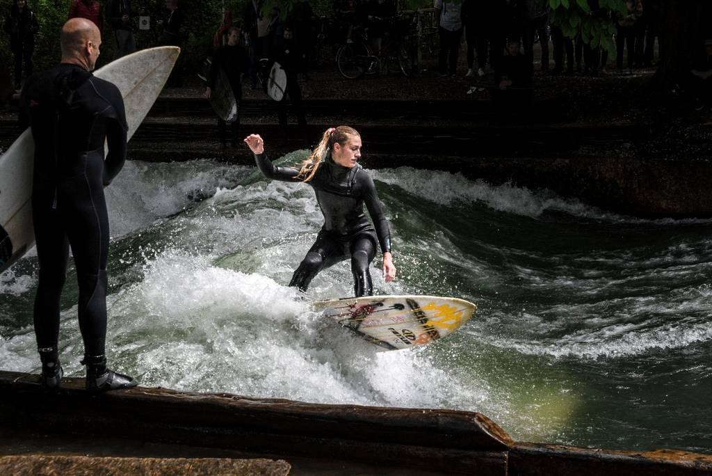 surferin auf der Eisbachwelle München