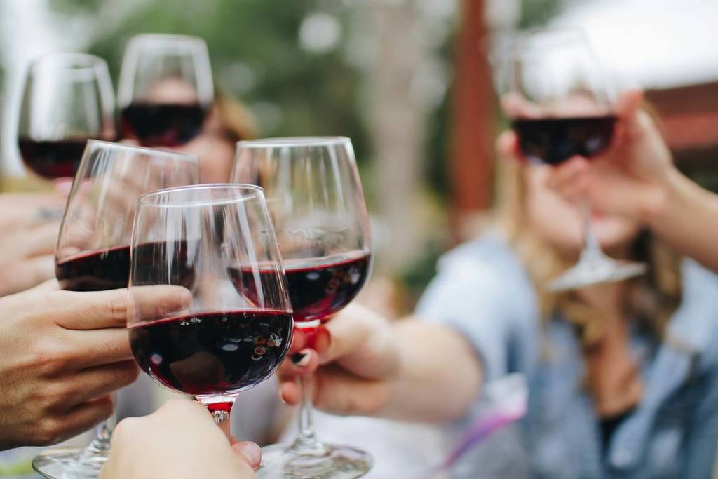 personen stoßen mit rotwein an