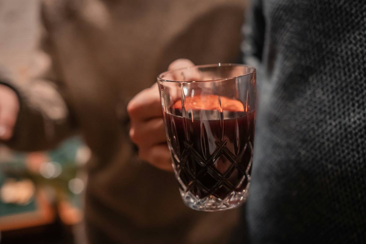 Person hält glas mit glühwein