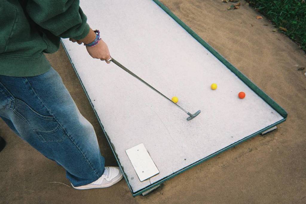 person standing at minigolf course