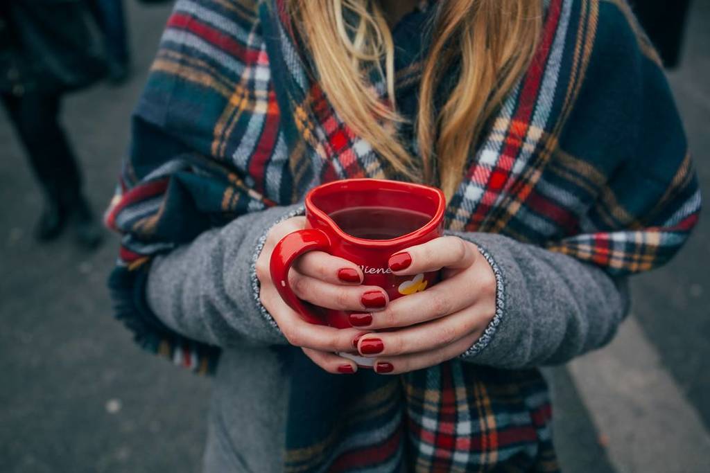 frau hält tasse mit glühwein