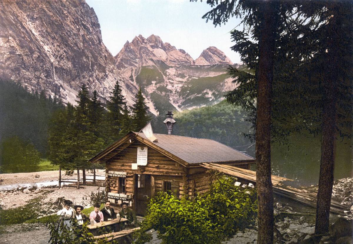 personen vor einer holzhütte am hochwanner um 1900