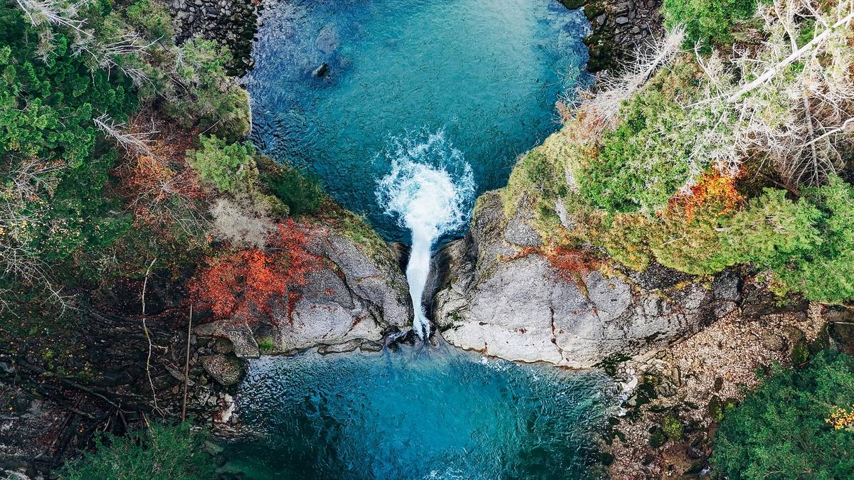 Zwei blaue Wasserbecken werden von einem Wasserfall verbunden