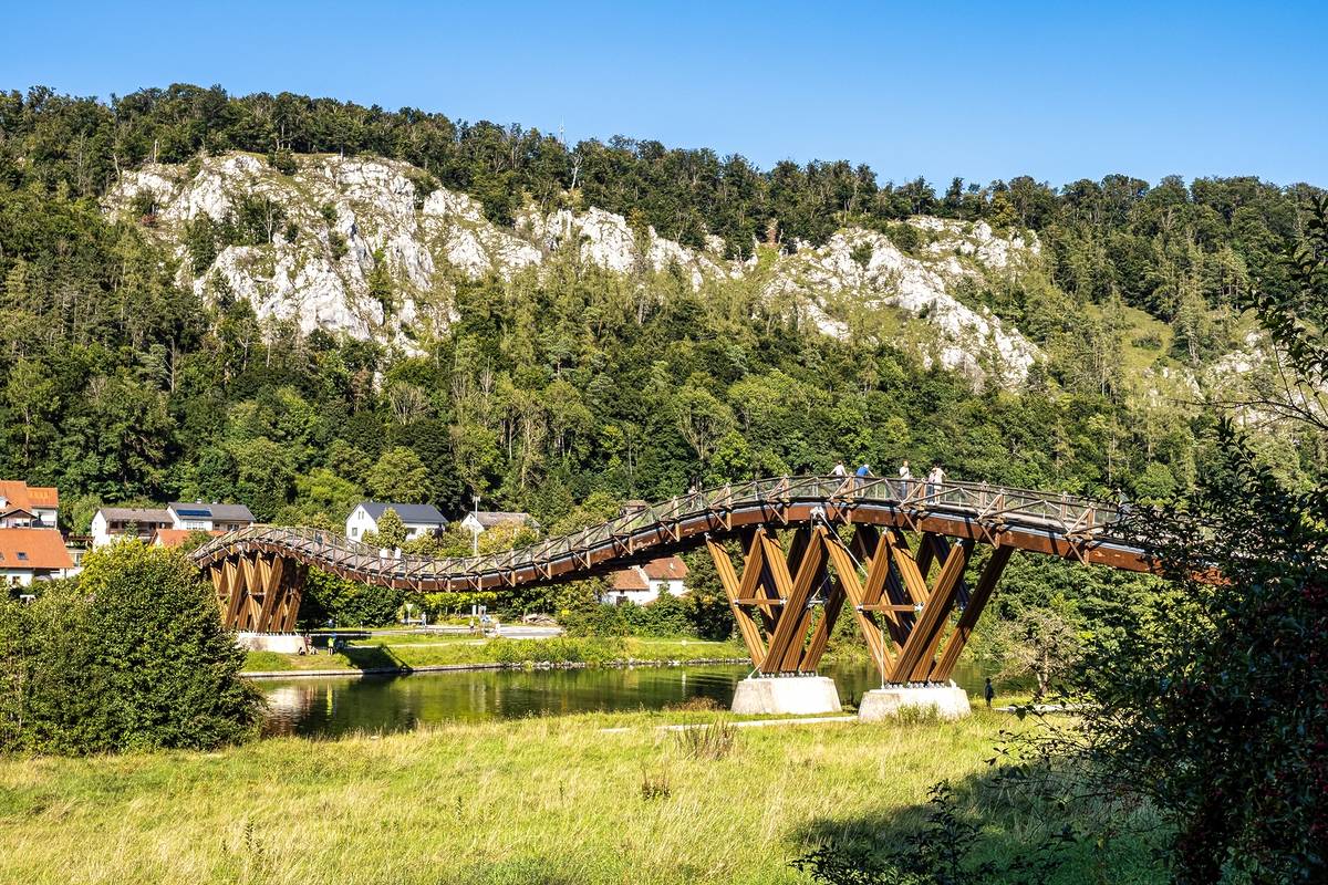 Geschwungene Brücke vor einem Bergpanorama