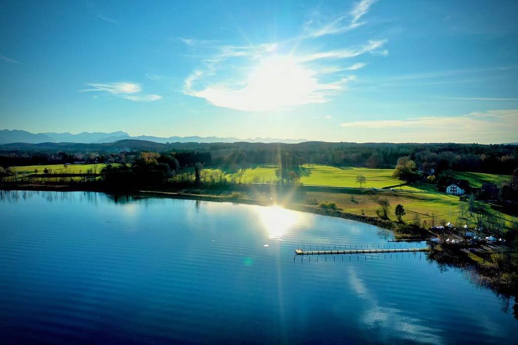 sun reflects in one of the Osterseen lakes from above