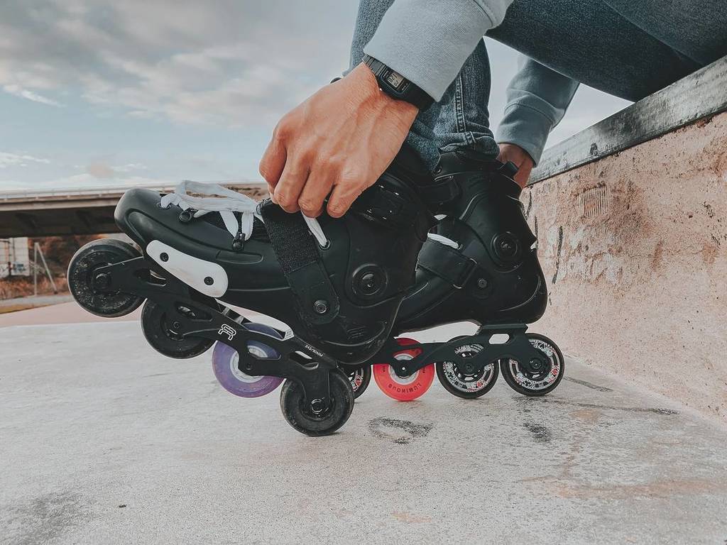 person lacing up inline skates
