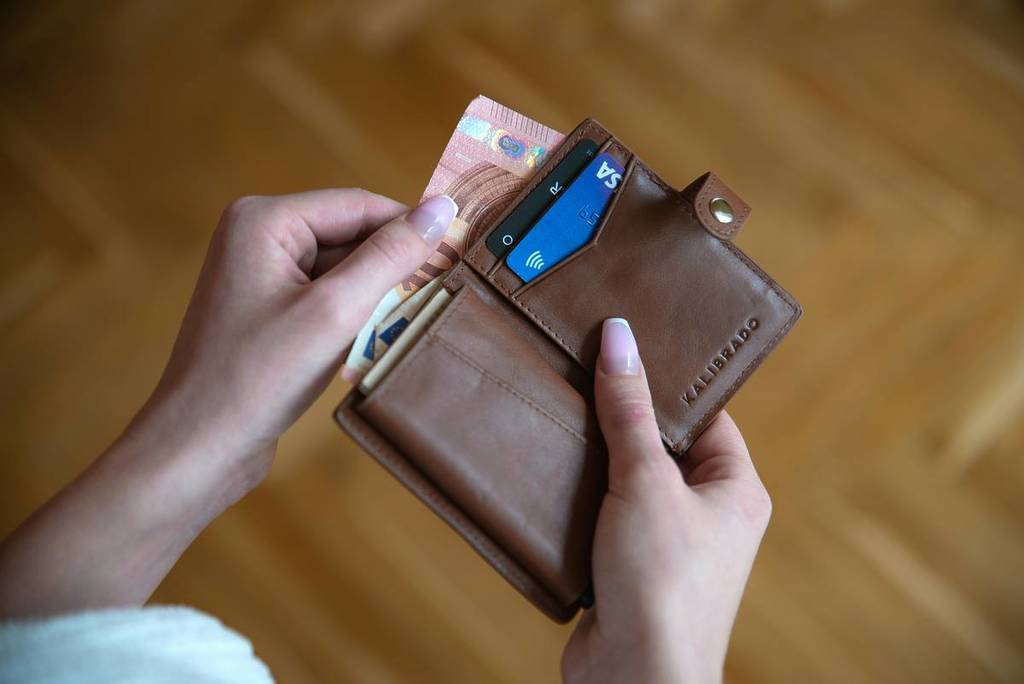woman pulls a €10 bill out of her wallet
