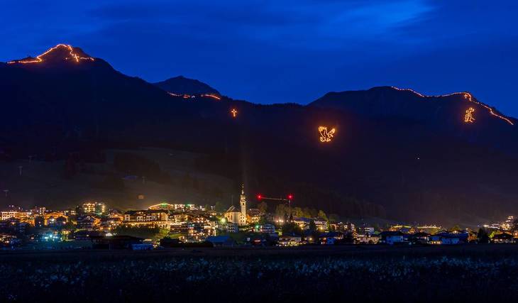 Etwa 2,5 Stunden von München leuchten am längsten Tag des Jahres bis zu 10.000 Feuer in den Tiroler Alpen und feiern mit diesem UNESCO-Kulturerbe die Sommersonnenwende