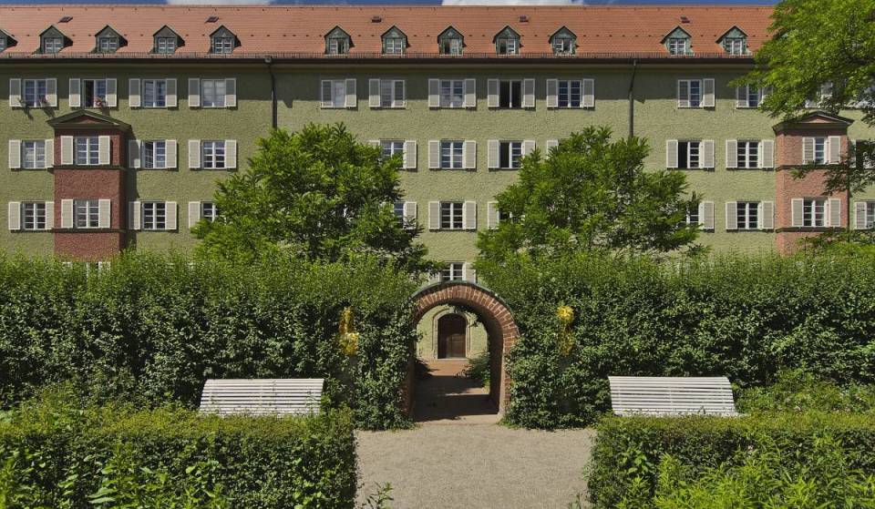 Im Münchner Nordwesten liegt auf 70.000 m² ein einzigartiges, kunstvolles Wohnviertel mit eigenem Rosengarten und dem kleinsten Museum Münchens, das ihr kostenlos besucht