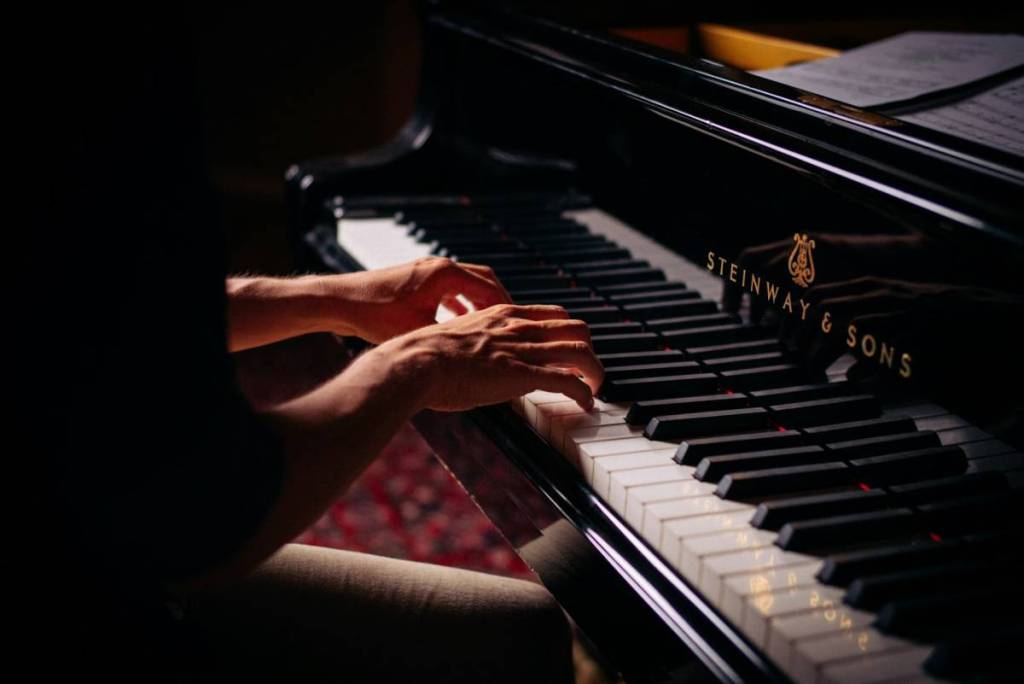 A person sits at the piano and plays