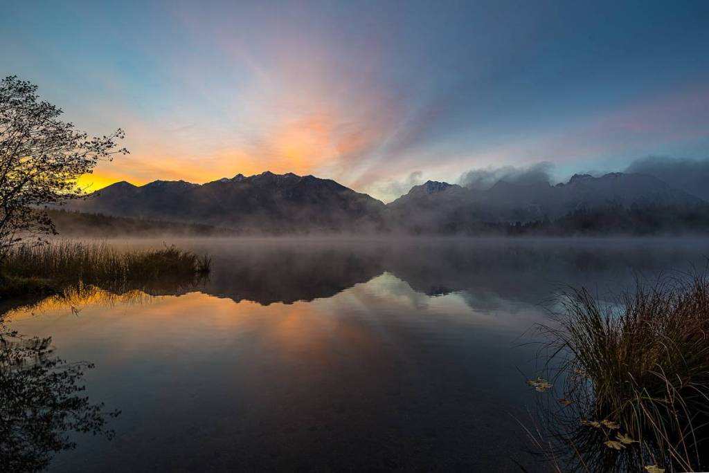 sonnenuntergang über den bergen am barmsee