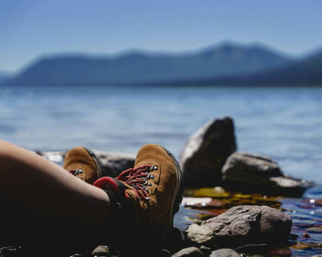 person mit wanderschuhen am wasser