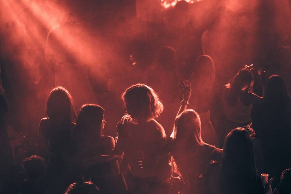 women dance under red lights at the club